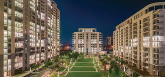 Night view of Saan Vardante in Sector 95, Gurugram showcasing premium apartment towers, landscaped central greens, illuminated walkways, and a secure gated residential community.